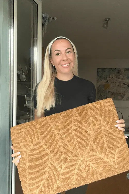 Happy blonde women customer with doormat and black shirt
